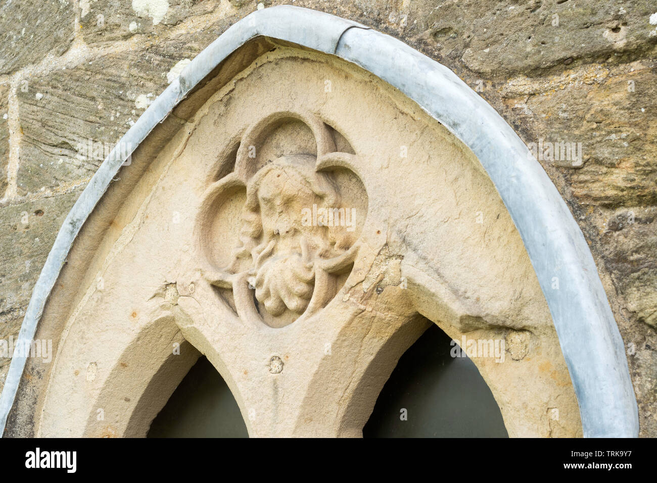 Steinerne Gesicht oberhalb des Fensters in er mittelalterliche Herrenhaus Aydon Hall, in der Nähe der South Brent, Northumberland, England, Großbritannien Stockfoto