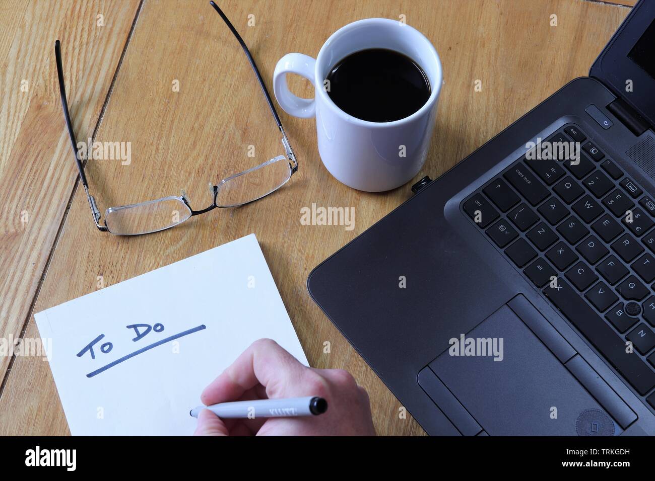 Flach auf dem Schreibtisch, mit Aufgabenliste, Gläser, Kaffee und Laptop Stockfoto