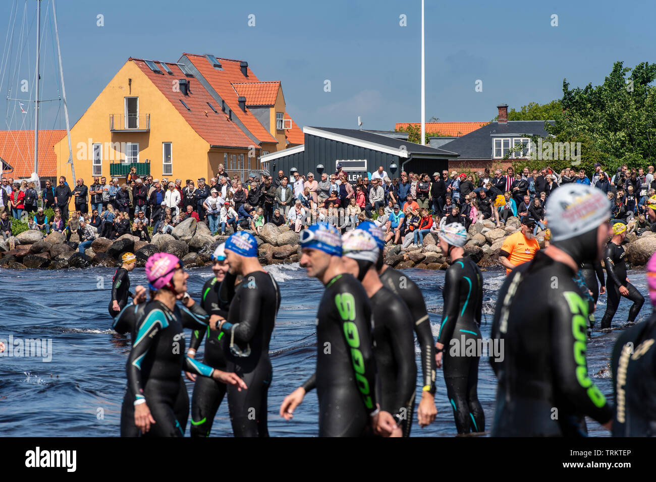 Große Gruppen von triathlon Kämpfer warten ins Meer während der Hals Triathlon in Dänemark laufen zu lassen. Die Teilnehmer tragen Anzüge Stockfoto