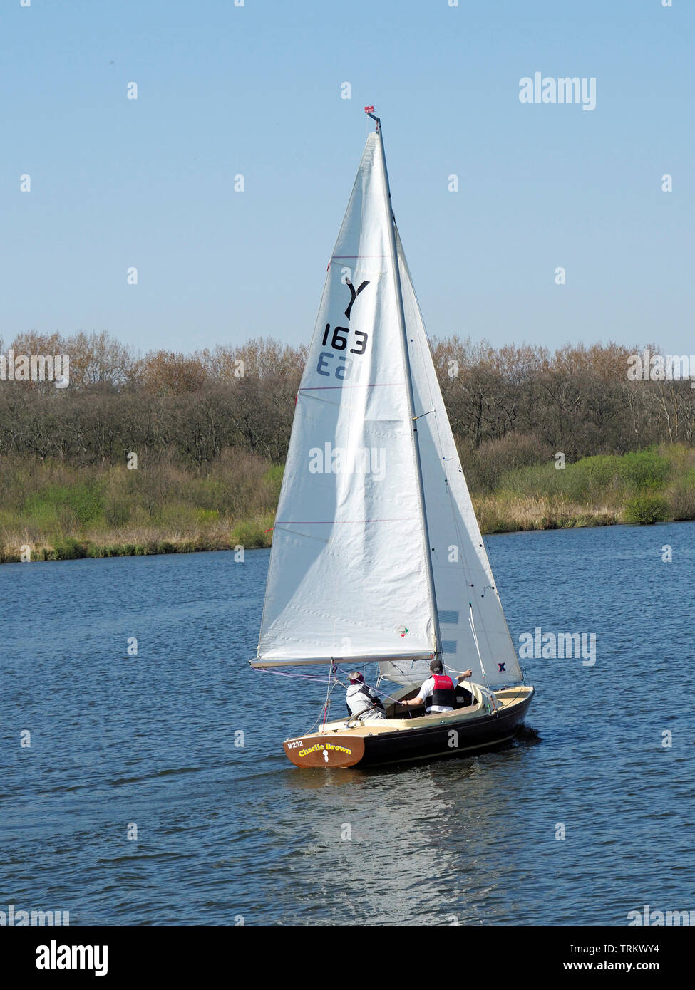 Segeln ist ein beliebter Zeitvertreib auf der Norfolk Broads. Das kleine Segelboot seine Bahn auf der Rover Bure in der Nähe von Wroxham. Stockfoto