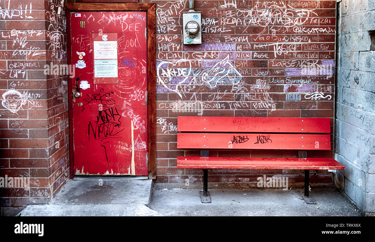 Brick Wall mit Sitzbank und ein Graffiti an der Wand mit einem Leistungsmesser Stockfoto