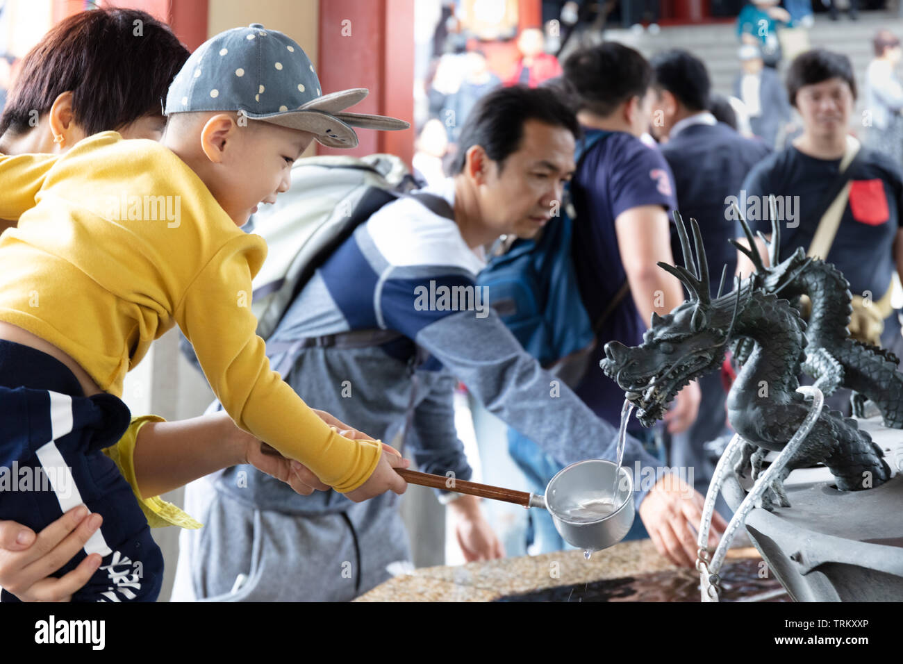Inhaber der Vater seinen Sohn über die reinigende Drachen Brunnen in Tokio, Japan. Stockfoto