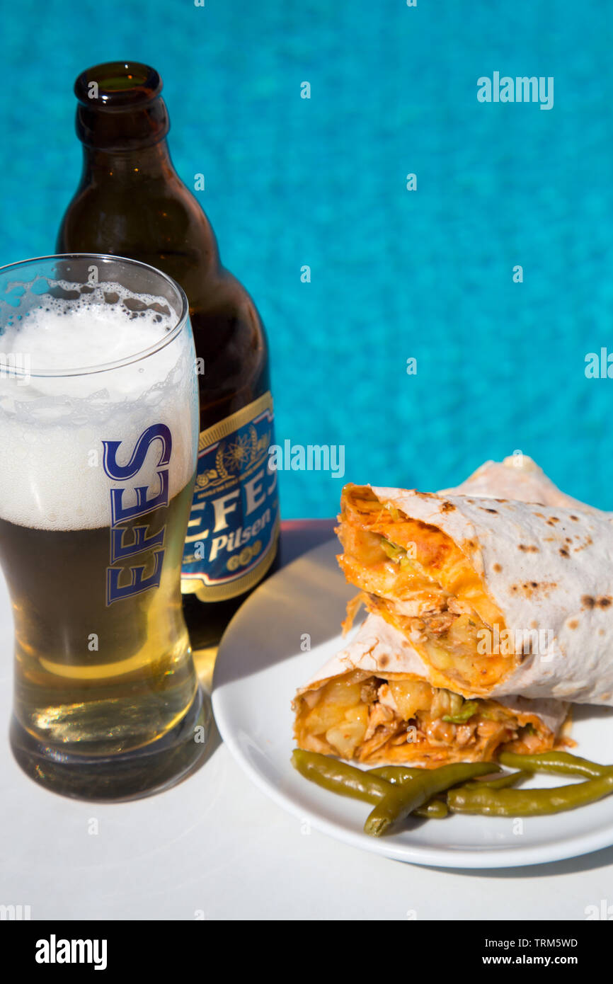 Eine Platte der Türkischen chicken Kebab (Tavuk Hartweizen} mit eine kalte Flasche Efes Pilsen Bier an einem sonnigen Nachmittag serviert am Pool, Marmaris, Türkei Stockfoto