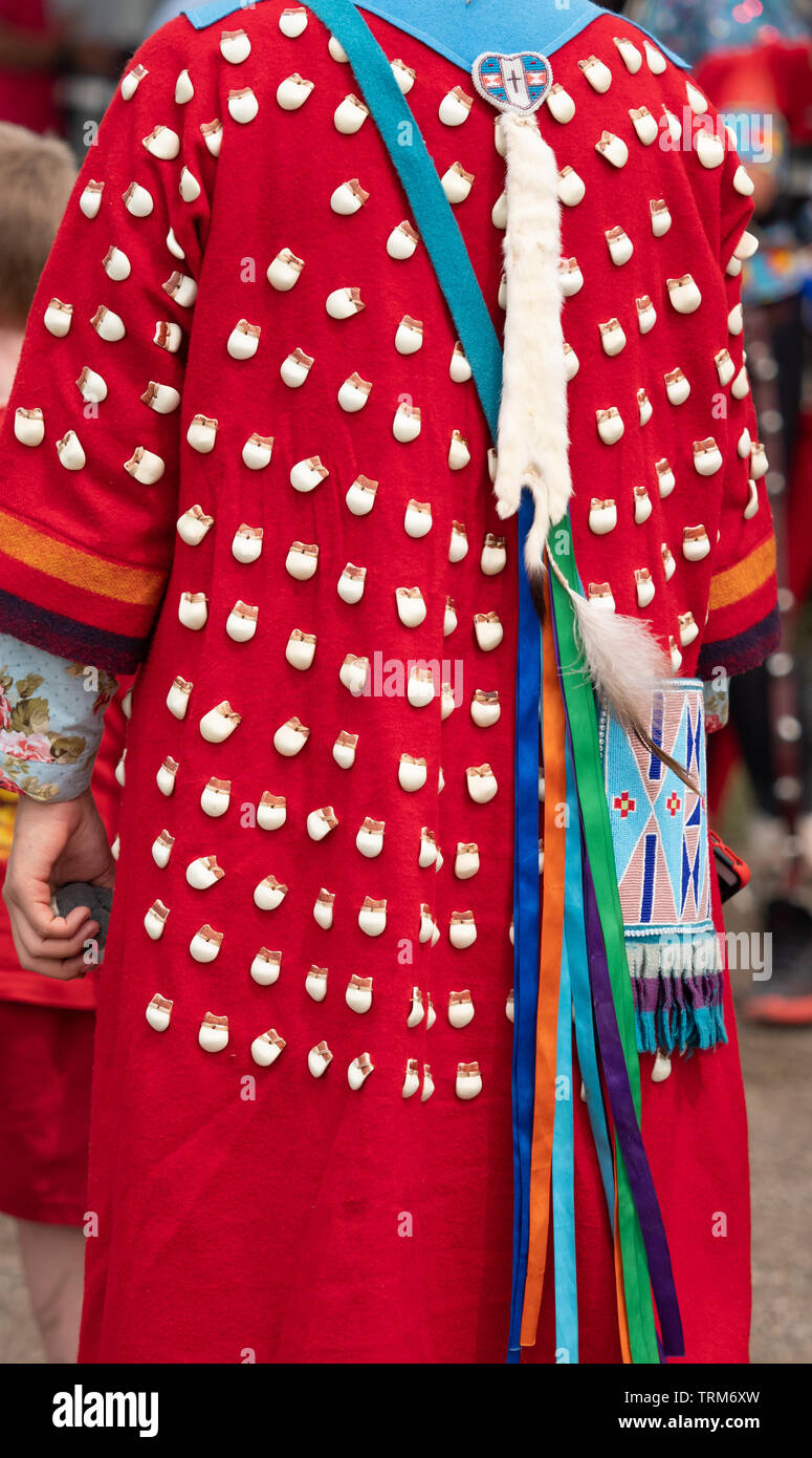 Nahaufnahme von einem traditionellen elk Zahn Kleid auf rotem Filz verschlissen durch weibliche Pow Wow Dancer. Frau trägt auch ein wulstiger Geldbeutel. Von hinten fotografiert. Stockfoto