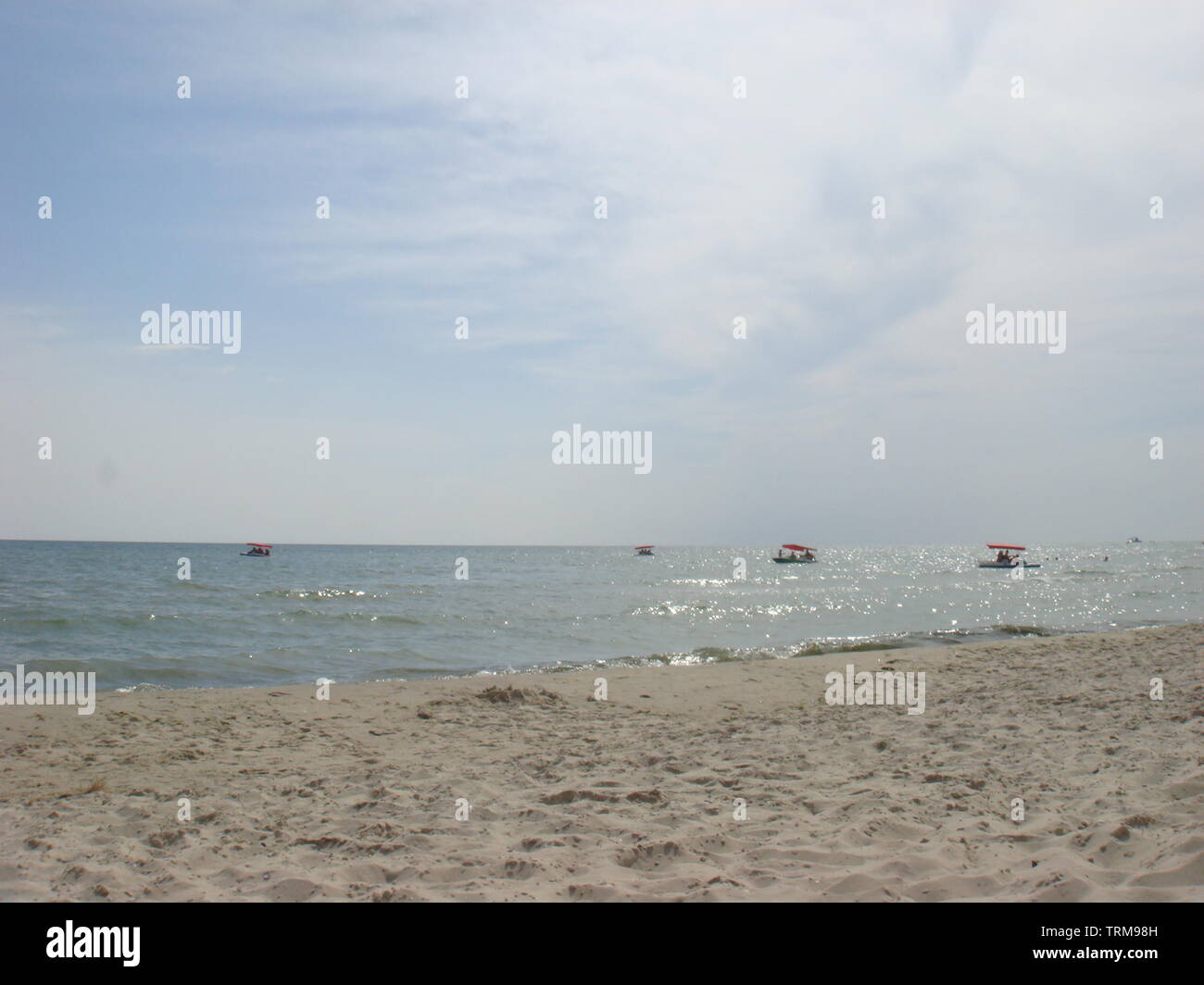 Katamarane auf blauem Meer und Himmel Hintergrund. Blick vom Strand. Menschen Skates auf dem Wasser von Tretboot mit Folie für den Abstieg ins Meer Stockfoto