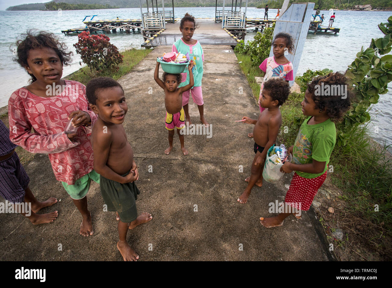 Papua Kinder mit einigen der Kunststoff marine Müll gesammelt haben, während ein windiger Tag in Manyaifun auf der Insel Batang Pe spielen Stockfoto