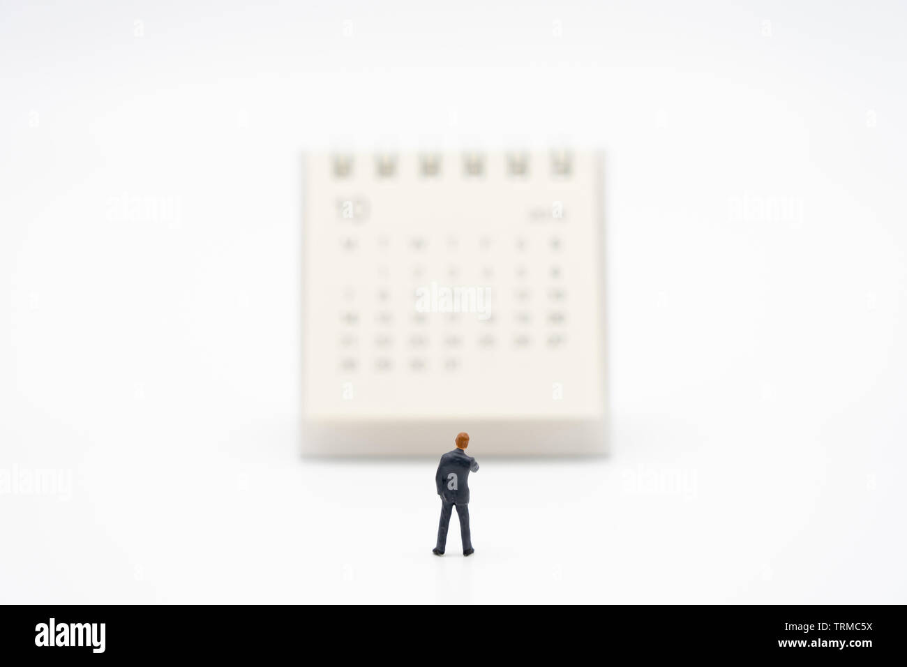 Miniatur Menschen Unternehmer stehen auf weißen Kalender als Hintergrund Business Konzept und Finanzierung Konzept mit Kopie Platz für Ihren Text oder de Stockfoto