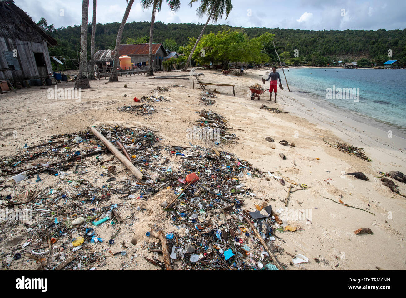 Insel Papua Dorfbewohner Clearing bis Kunststoff marine Müll am Strand gedumpten in Manyaifun während einer windigen Tag auf der Insel Batang Pele, West Wa Stockfoto