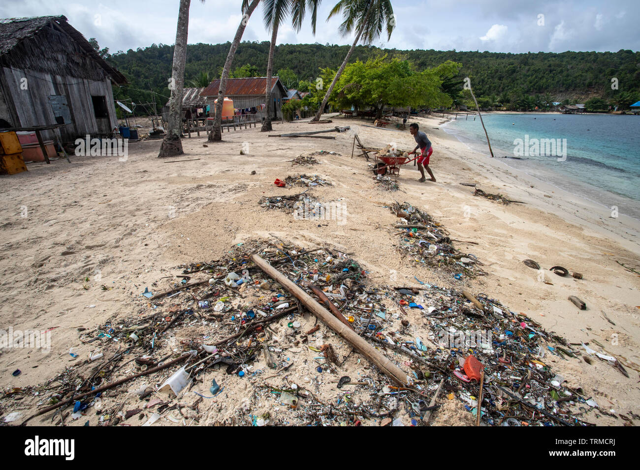 Insel Papua Dorfbewohner bis clearing Kunststoff marine müll entleert auf den Strand in Manyaifun während einer windigen Tag auf der Insel Batang Pele, West Wai Stockfoto