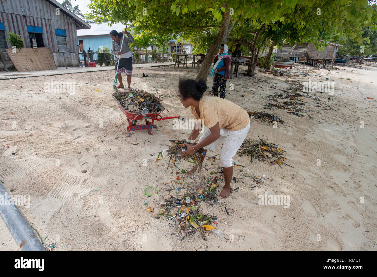 Insel Papua Dorfbewohner Clearing bis Kunststoff marine Müll am Strand gedumpten in Manyaifun während einer windigen Tag auf der Insel Batang Pele, West Wa Stockfoto