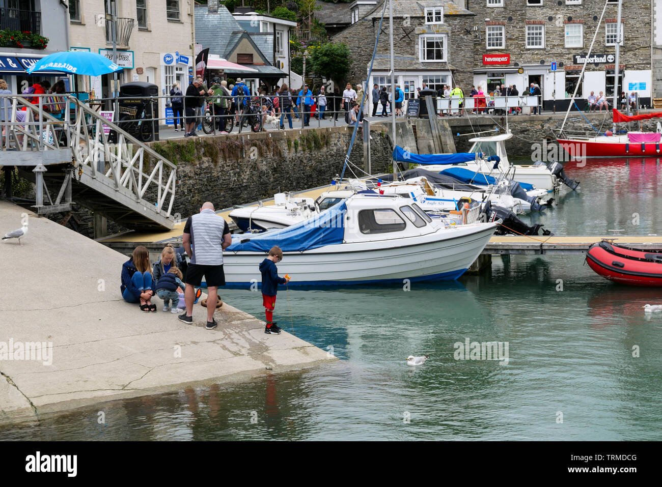Padstow, Cornwall, England, Großbritannien: eine Familie die Fischerei auf Krebse auf der Helling mit dem Hafen und Boote hinter sich. Stockfoto