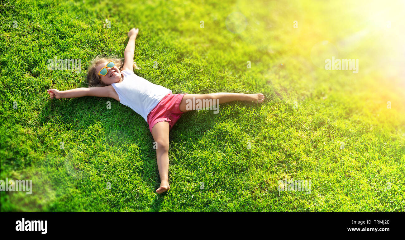 Lächelnde Mädchen liegen auf Gras Wiese Stockfoto