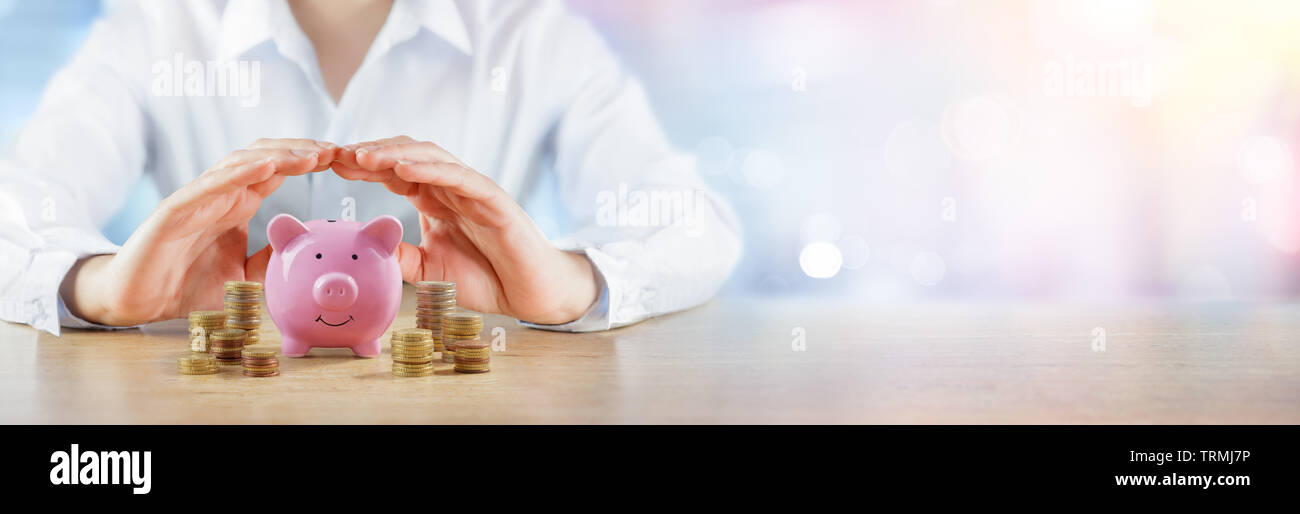 Schützen Sie Ihre Ersparnisse - Banking und Qualitätssicherung Konzept - Hände über Sparschwein mit Geld Stapel Stockfoto