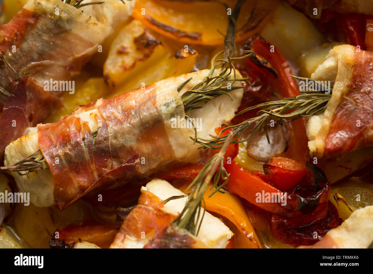 Filets von line-gefangen Pollack Pollachius pollachius, die im Knoblauch und Zitronensaft, bevor in Parmaschinken mit Fre eingewickelt zu werden, mariniert worden sind Stockfoto