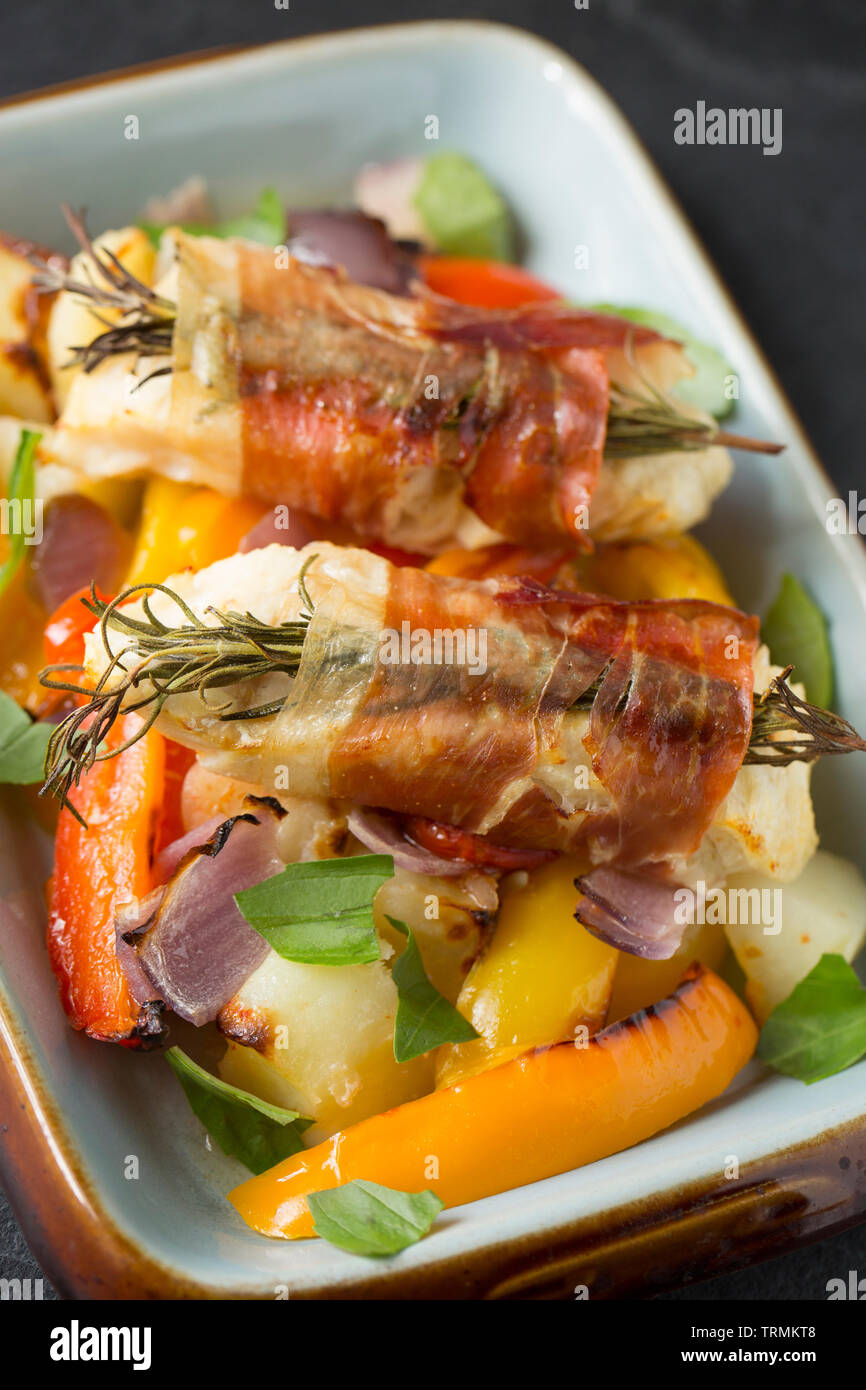 Filets von line-gefangen Pollack Pollachius pollachius, die im Knoblauch und Zitronensaft, bevor in Parmaschinken mit Fre eingewickelt zu werden, mariniert worden sind Stockfoto