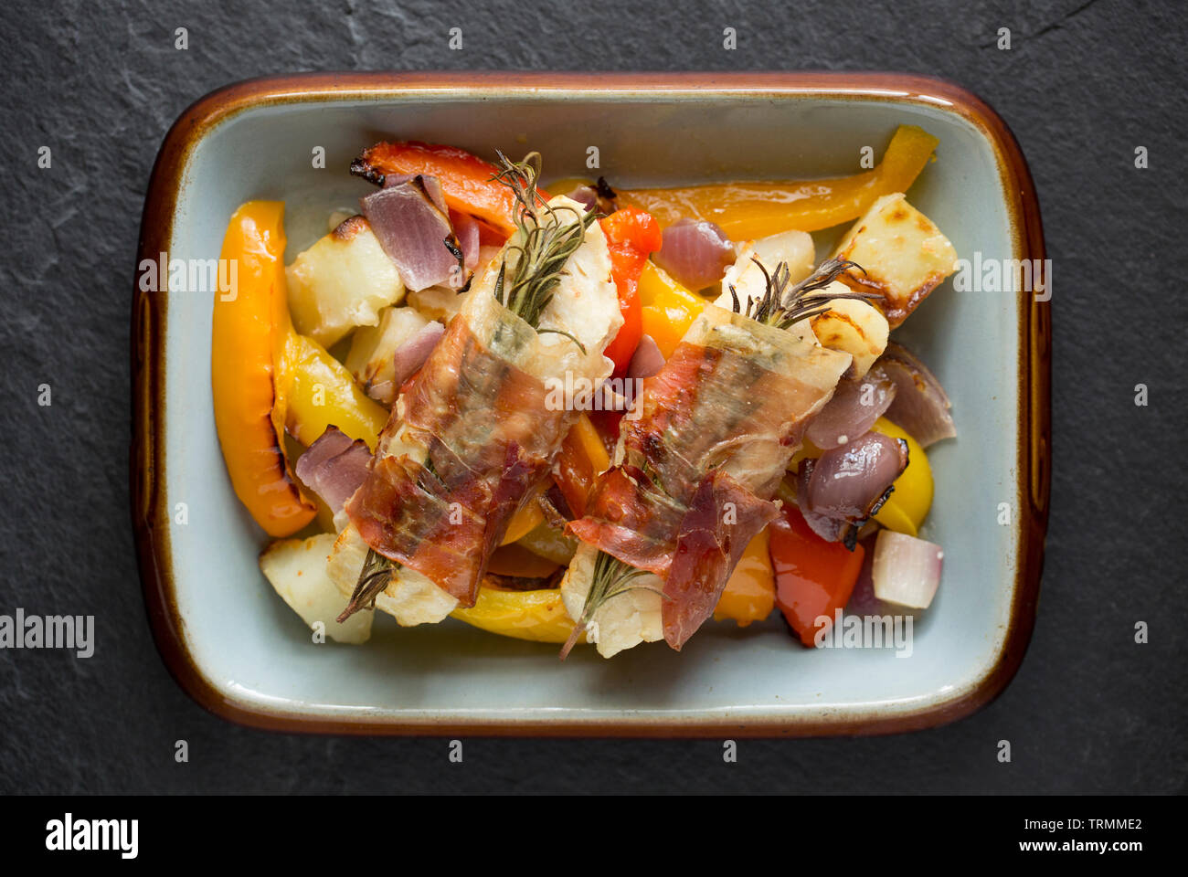 Filets von line-gefangen Pollack Pollachius pollachius, die im Knoblauch und Zitronensaft, bevor in Parmaschinken mit Fre eingewickelt zu werden, mariniert worden sind Stockfoto