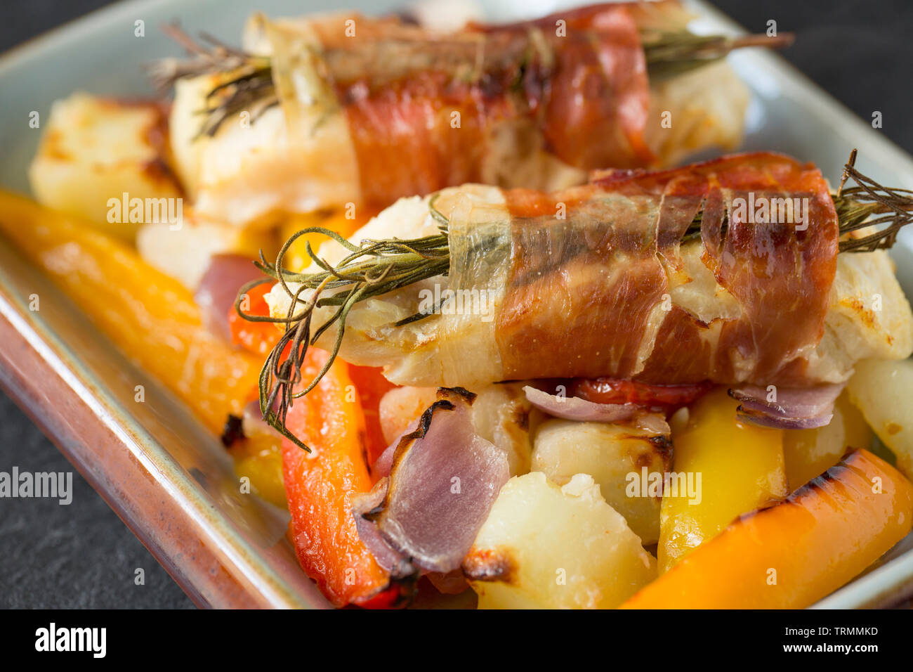 Filets von line-gefangen Pollack Pollachius pollachius, die im Knoblauch und Zitronensaft, bevor in Parmaschinken mit Fre eingewickelt zu werden, mariniert worden sind Stockfoto