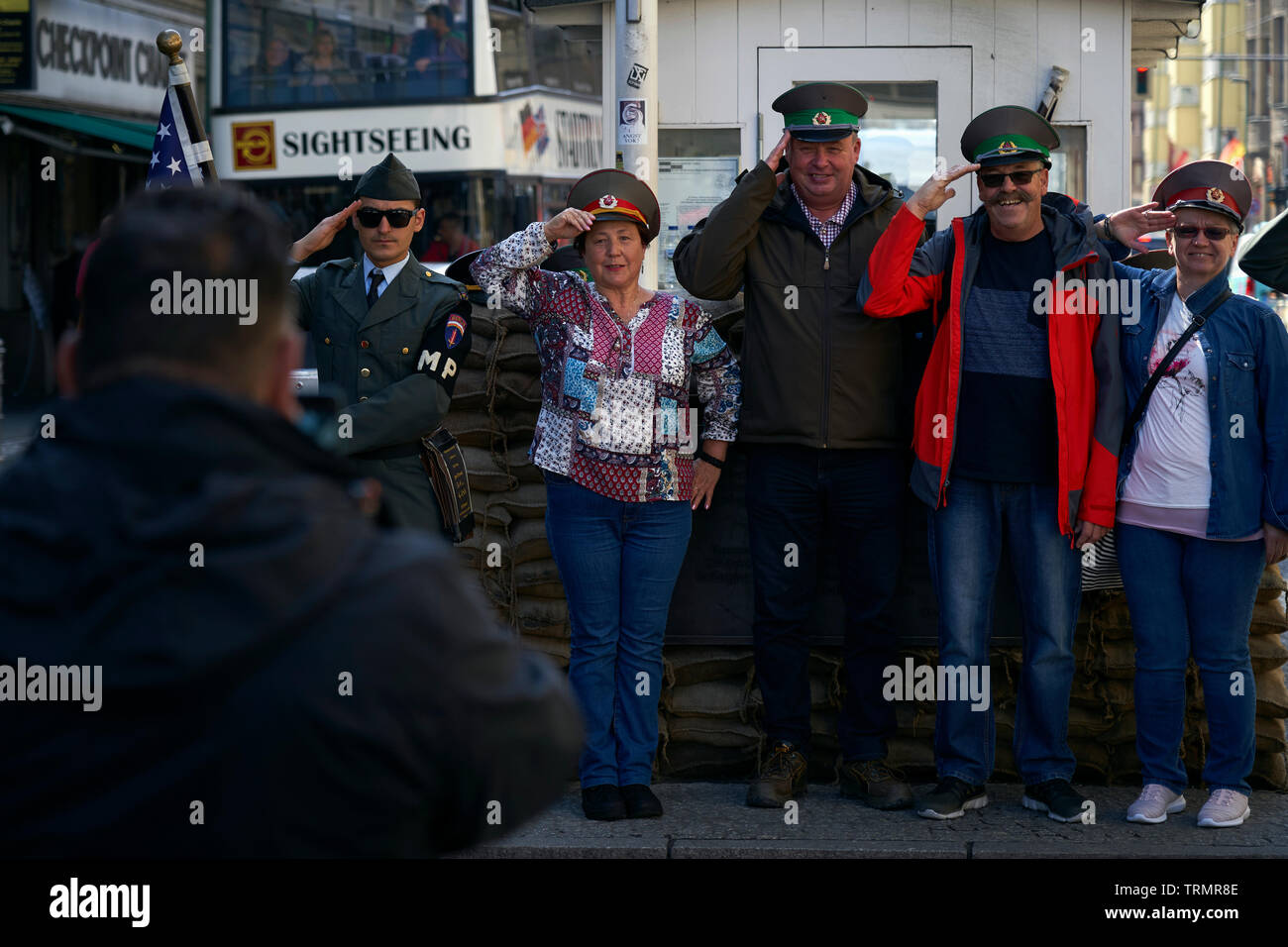 Eine Gruppe von Touristen fotografiert an eine touristische Attraktion, wo Checkpoint Charlie verwendet werden. Stockfoto