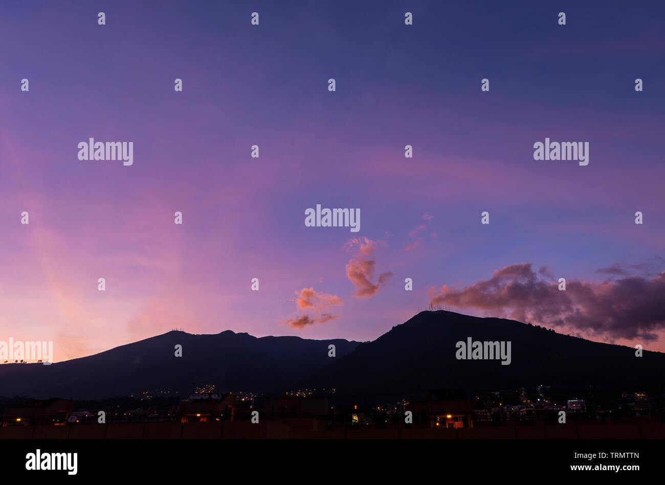 Ein magic purple Sunset mit der Silhouette des Vulkan Pichincha in den Anden, Quito, Ecuador. Stockfoto
