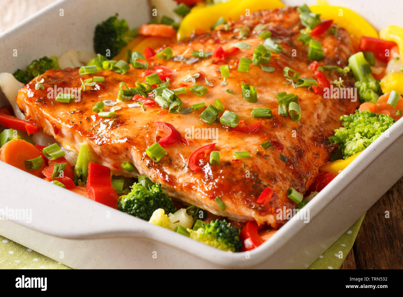 Gebackenen Lachs mit Sommergemüse close-up in einer Auflaufform auf den Tisch. Horizontale Stockfoto