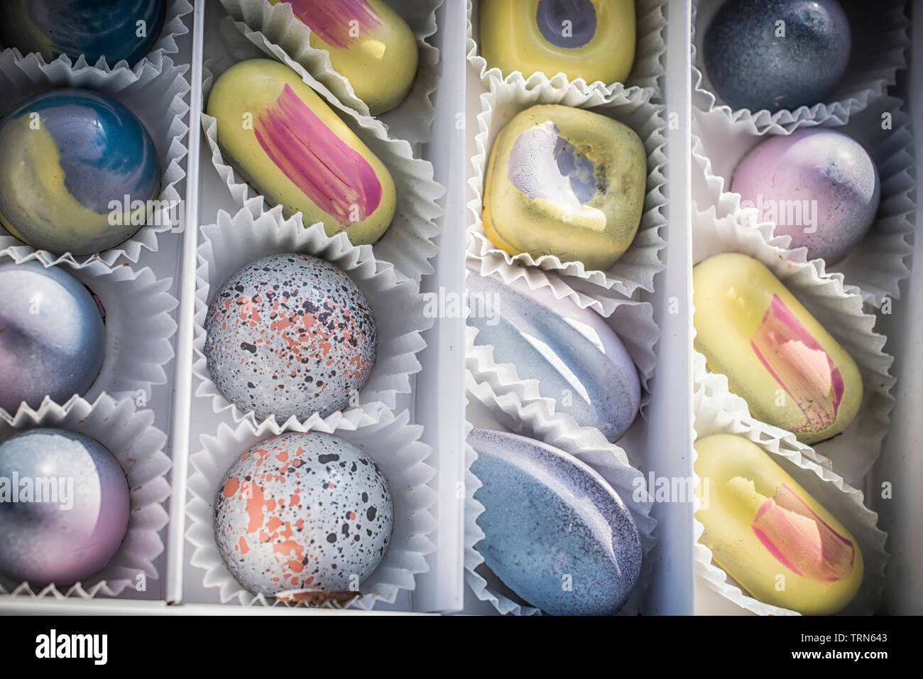 Eine Schachtel Pralinen in Pastellfarben sortiert Stockfoto