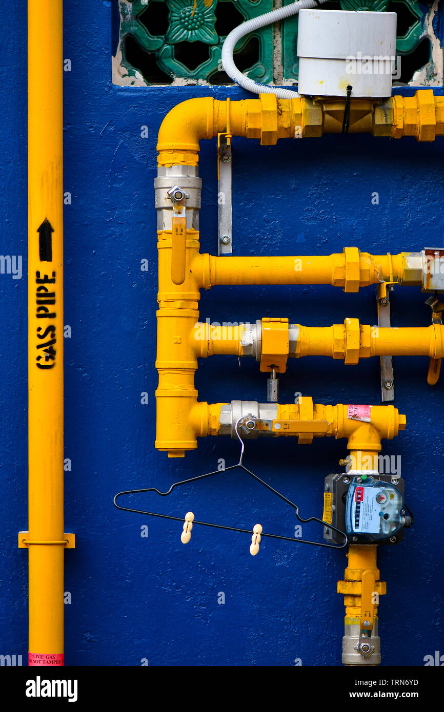 Blaue Wand mit gelben Gasleitungen Stockfoto
