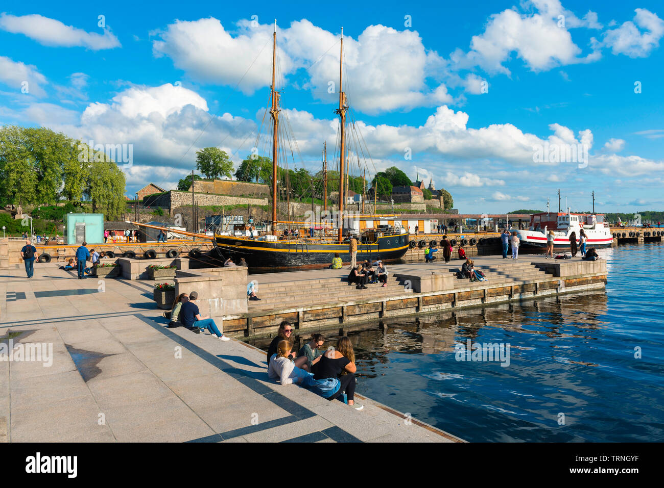 Oslo Norway Harbour, Blick auf junge Leute, die sich an einem Kai im Hafengebiet (Aker Brygge) in Oslo an einem Sommernachmittag entspannen, Norwegen. Stockfoto