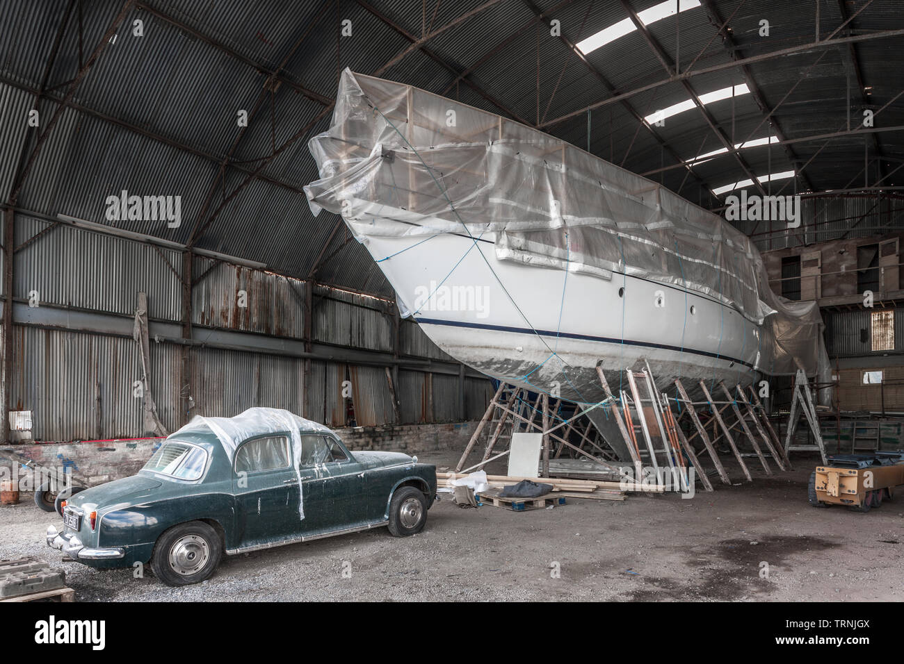 Crosshaven, Cork, Irland. 10 Juni, 2019. Ein alter Klassiker Rover 110 Auto und ein Ocean Racing Yacht, in der Lagerung in Crosshaven, Co Cork, Irland. Stockfoto