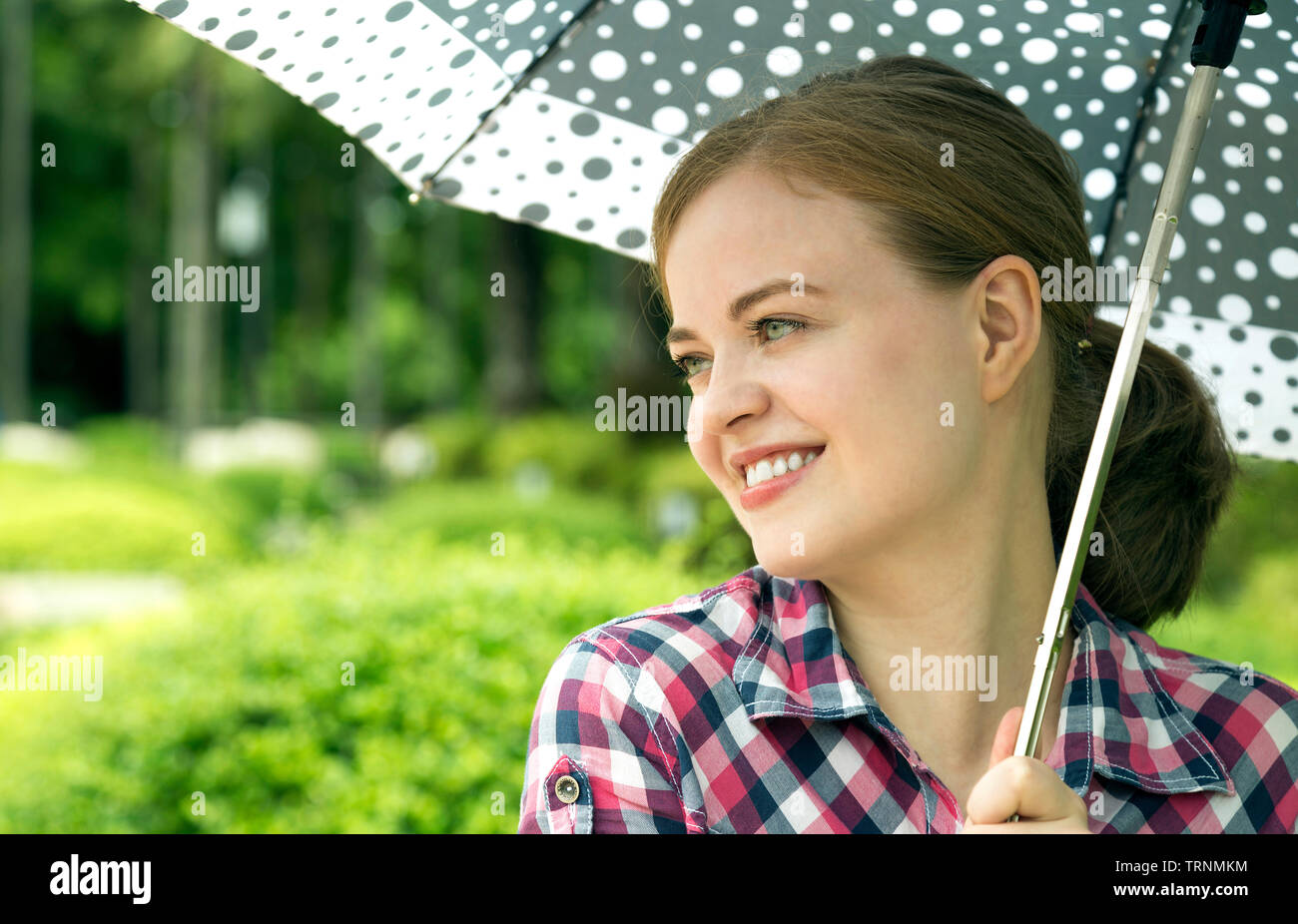 Junge kaukasier Frau mit Schirm Stockfoto