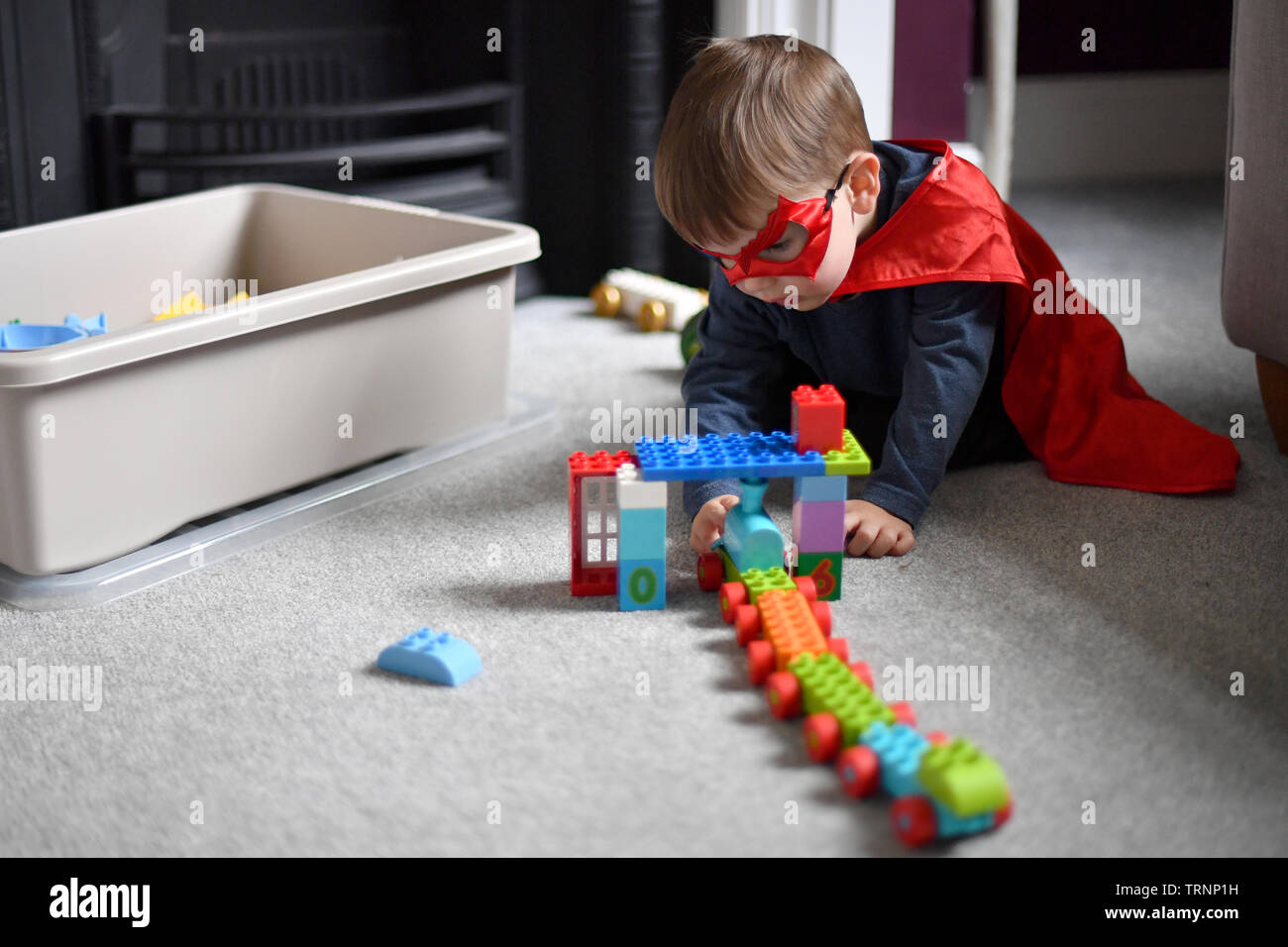 Ein junge Kleider in Gap und Maske spielt mit Lego duplo Bausteine Stockfoto