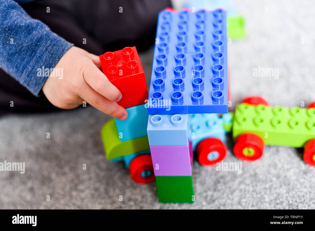 Ein junge Kleider in Gap und Maske spielt mit Lego duplo Bausteine Stockfoto