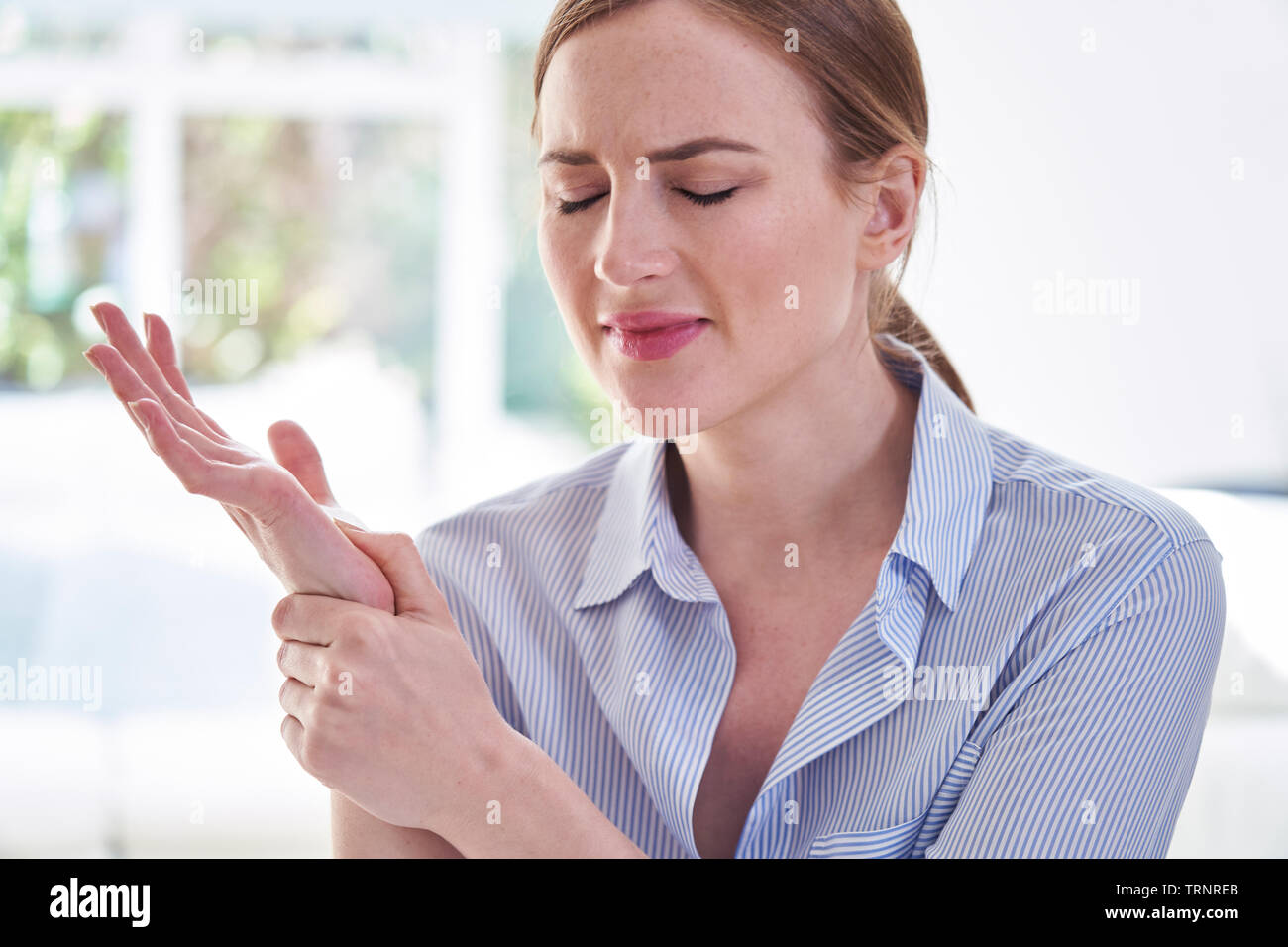 Frau In Schmerzen Holding Handgelenk Leiden mit Repetitive Strain Injury Stockfoto