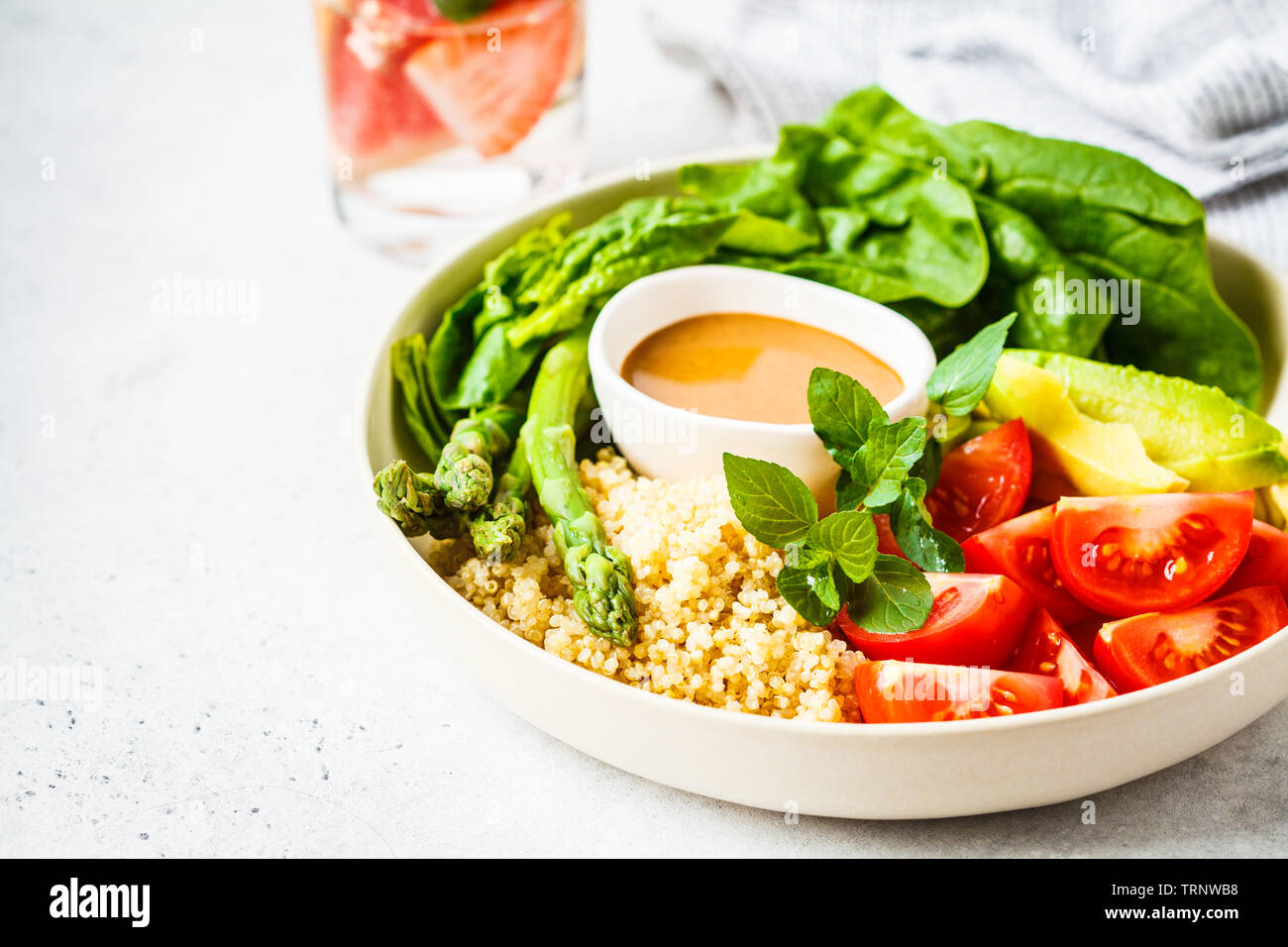 Grüner Salat mit Quinoa, Avocado und Spargel in einer weißen Schüssel. Veganes essen Konzept. Stockfoto