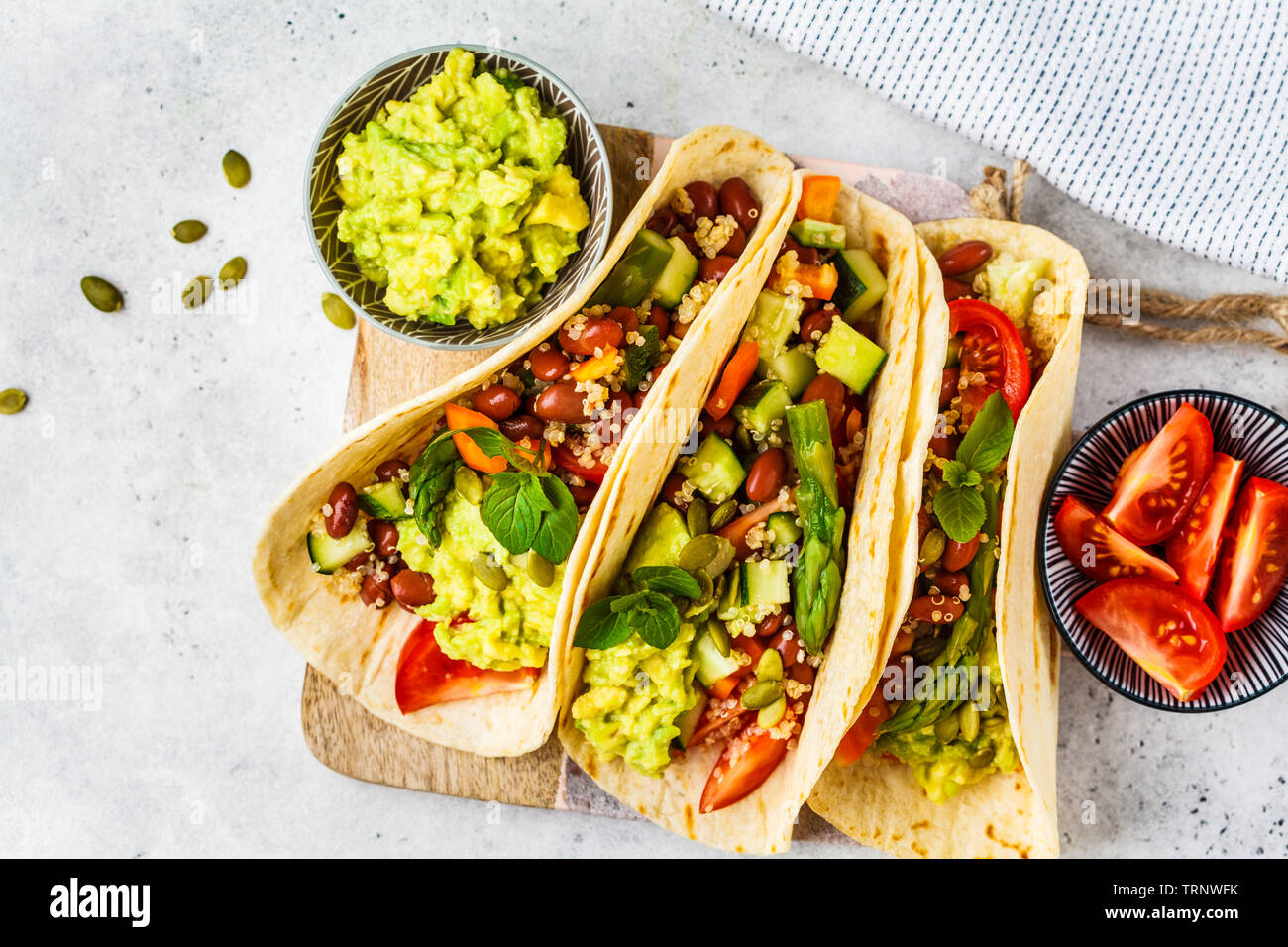 Vegan Tortilla Wraps mit Quinoa, Spargel, Bohnen, Gemüse und Guacamole. Stockfoto
