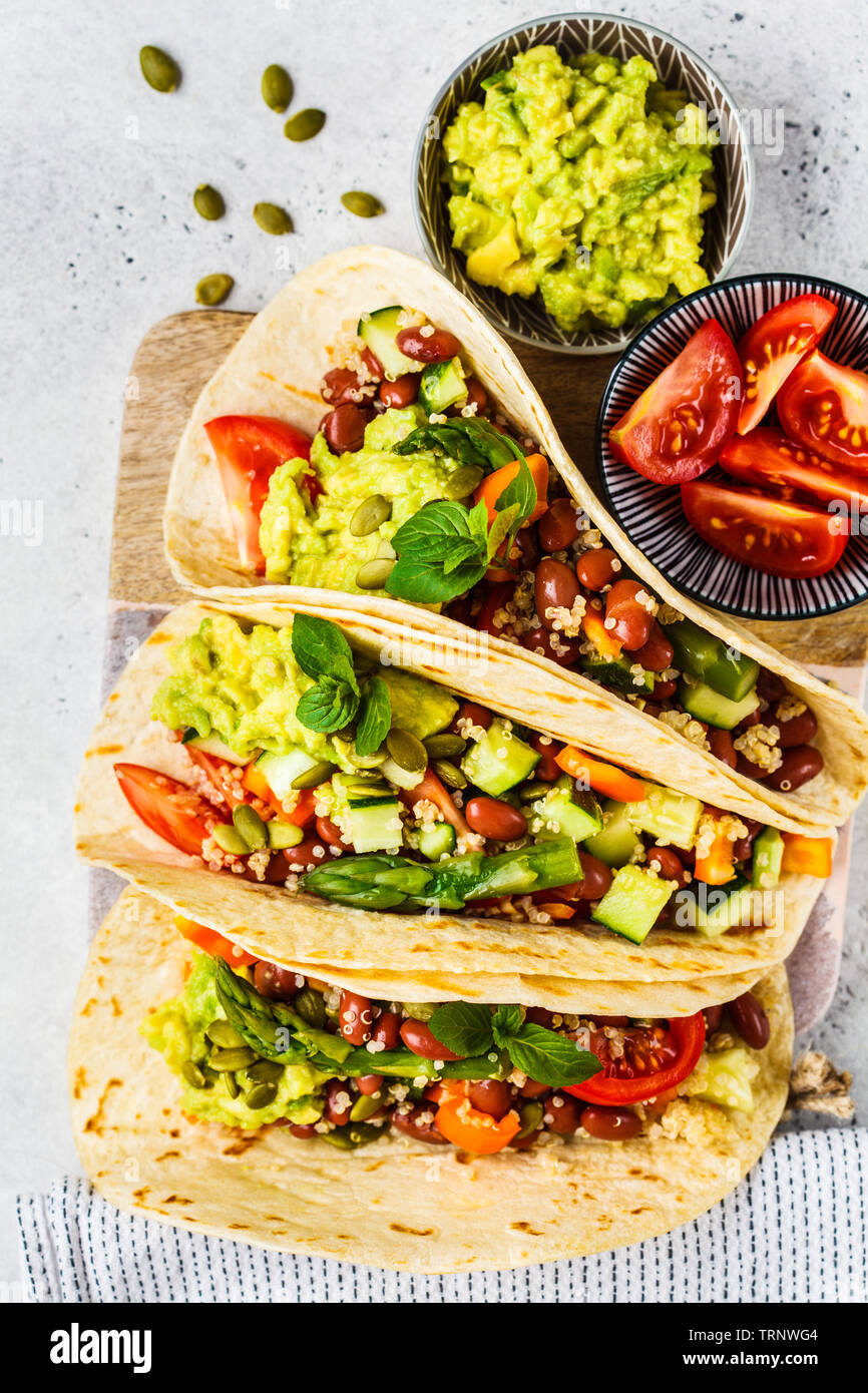 Vegan Tortilla Wraps mit Quinoa, Spargel, Bohnen, Gemüse und Guacamole. Stockfoto