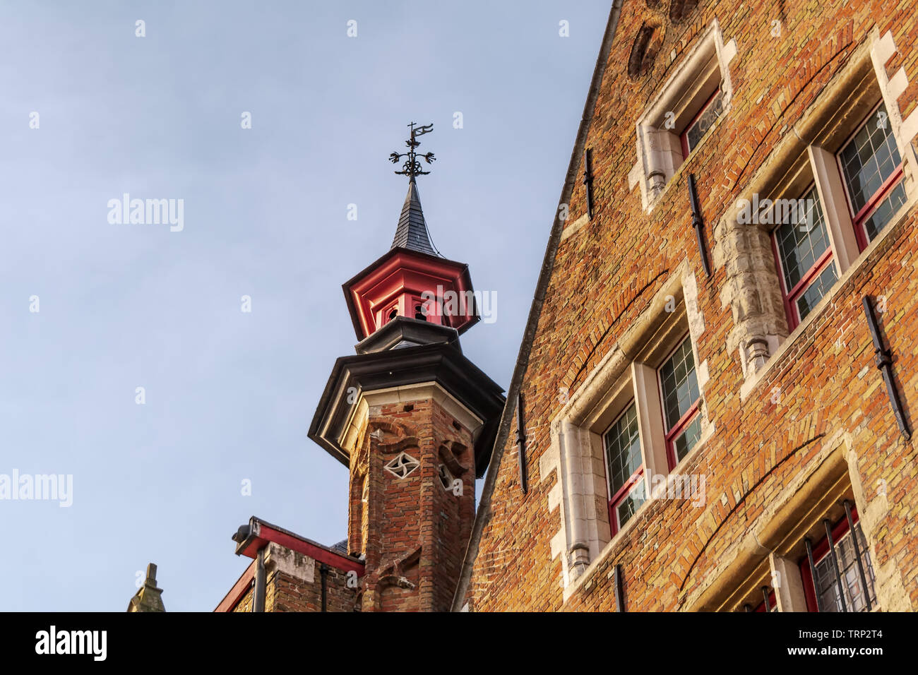 Eine der Backstein Türmchen von Landhuis van het Brugse Vrije (Palast der Freiheit von Brügge) mit roter Spitze und Wetterfahne. Stadtbild von Brügge Straßen Stockfoto