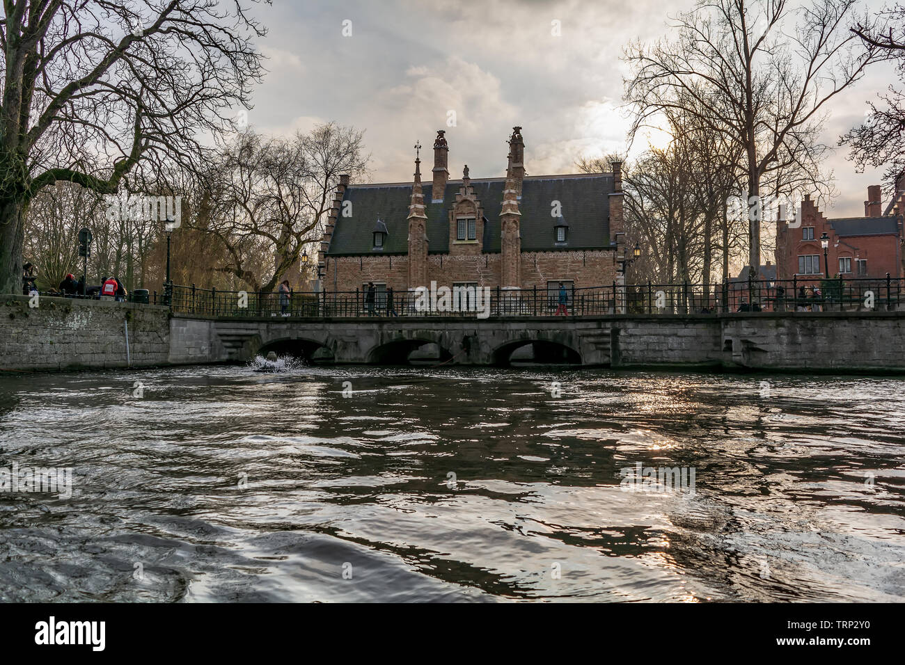 Malerische alte Straße von Brügge mit traditionellen mittelalterlichen Häusern, Kanal und Brücke. Stadtbild von Brügge Straßen erschossen vom Boot aus. Stockfoto