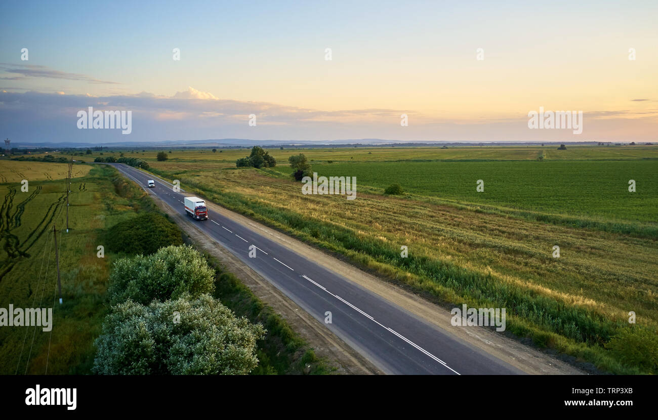 Lkw-Fahrten im Sommer auf der Straße bei Sonnenuntergang Stockfoto