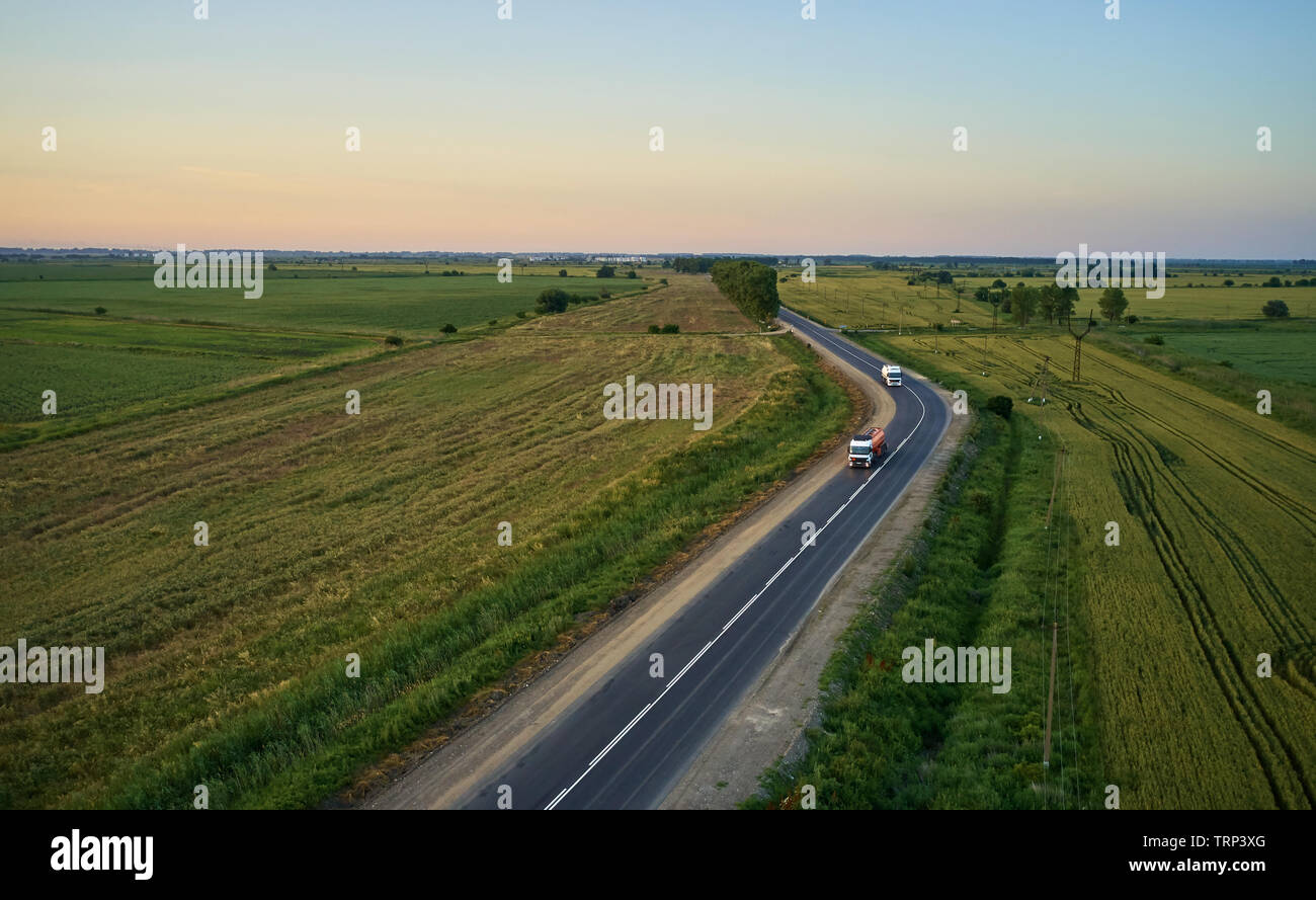 Lkw-Fahrten im Sommer auf der Straße bei Sonnenuntergang Stockfoto
