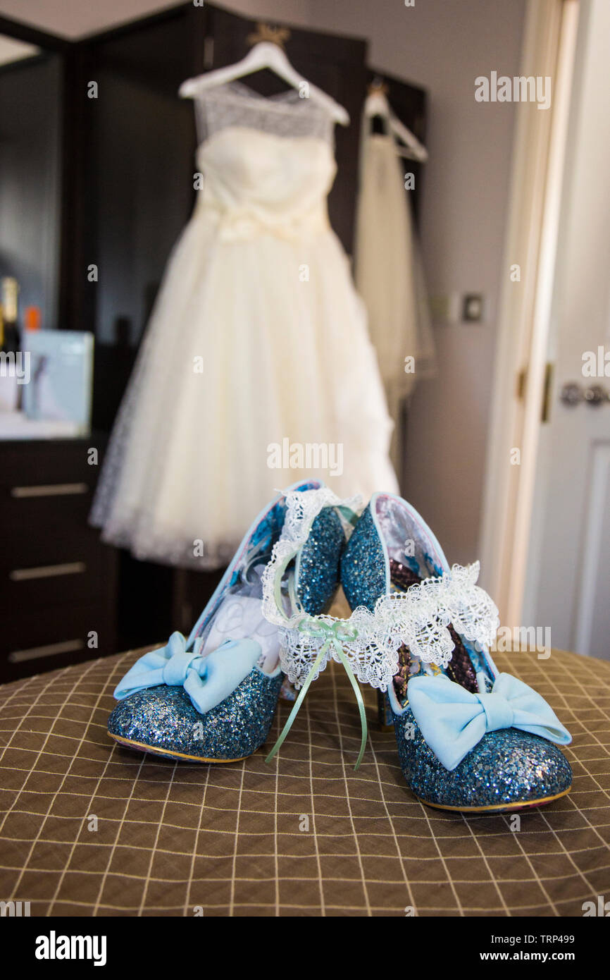 Bräute Hochzeit Kleid Auflegen mit Schuhen und Blumen an der Vorderseite des Foto, warten Alle getragen zu werden von der Braut an ihrem Hochzeitstag. Stockfoto