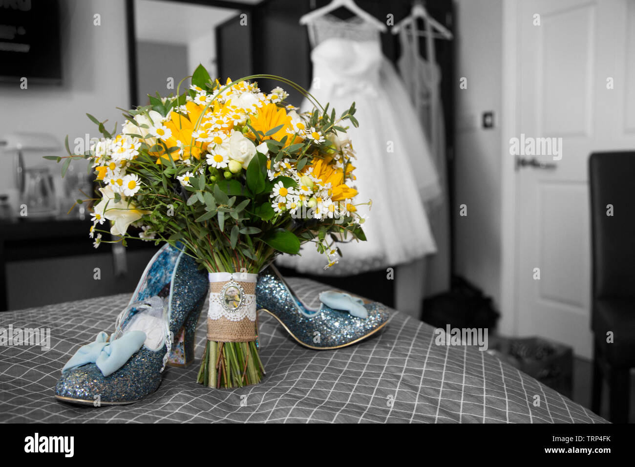 Bräute Hochzeit Kleid Auflegen mit Schuhen und Blumen an der Vorderseite des Foto, warten Alle getragen zu werden von der Braut an ihrem Hochzeitstag. Stockfoto