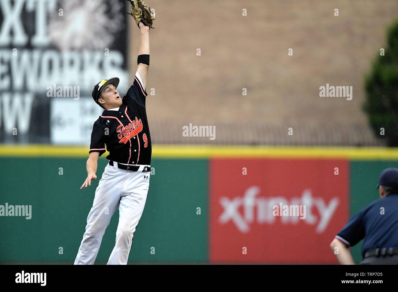 Shortstop sprang vom Boden zu fangen eine hohe von seinem Catcher, dass der Ball vom Segeln in das Feld gehalten zu werfen. USA. Stockfoto