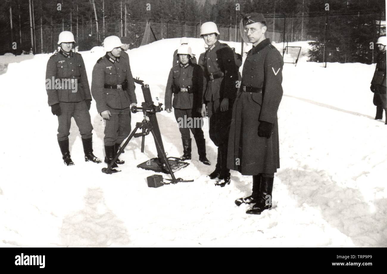 Deutsche Soldaten im Winter Mäntel mit weiß getünchten Helme Zug auf einem Mörser im besetzten Norwegen 1942 Stockfoto