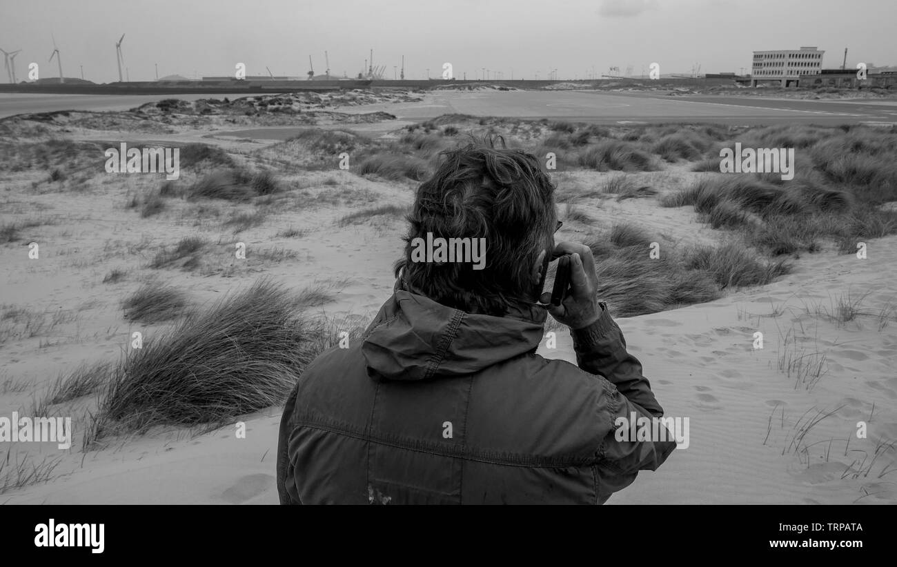 Menschen den Umgang mit einem Handy beim Wandern in den Dünen, Boulogne-sur-Mer, Ile de France, Frankreich Stockfoto