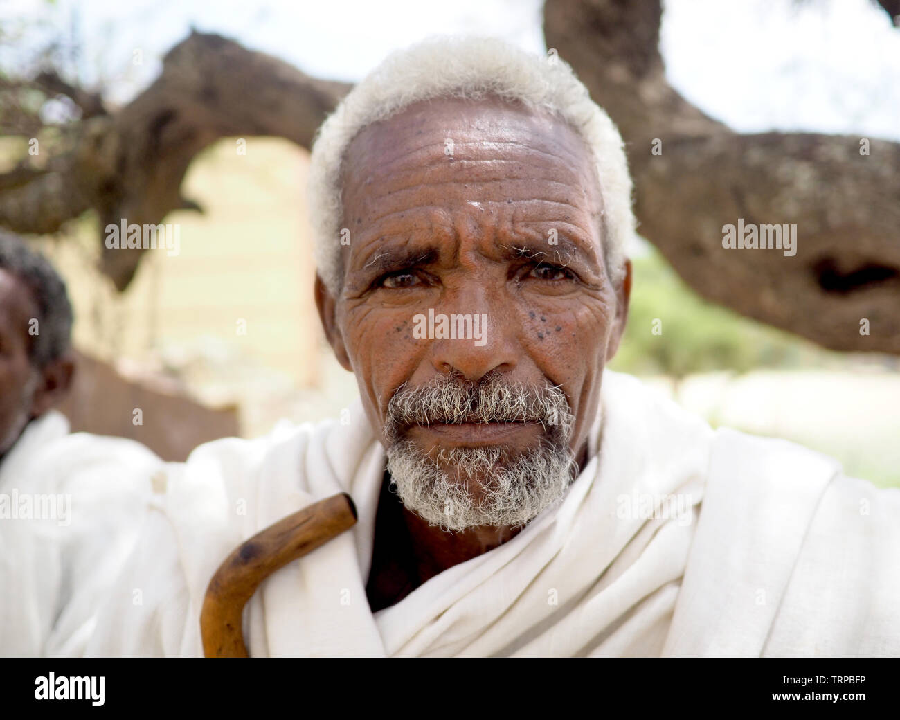 Alitena, Äthiopien - 1. Juni 2019: Alte Menschen im ländlichen Äthiopien, im traditionellen Weiß gekleidet Ritt, mit hölzernen Spazierstock Stockfoto