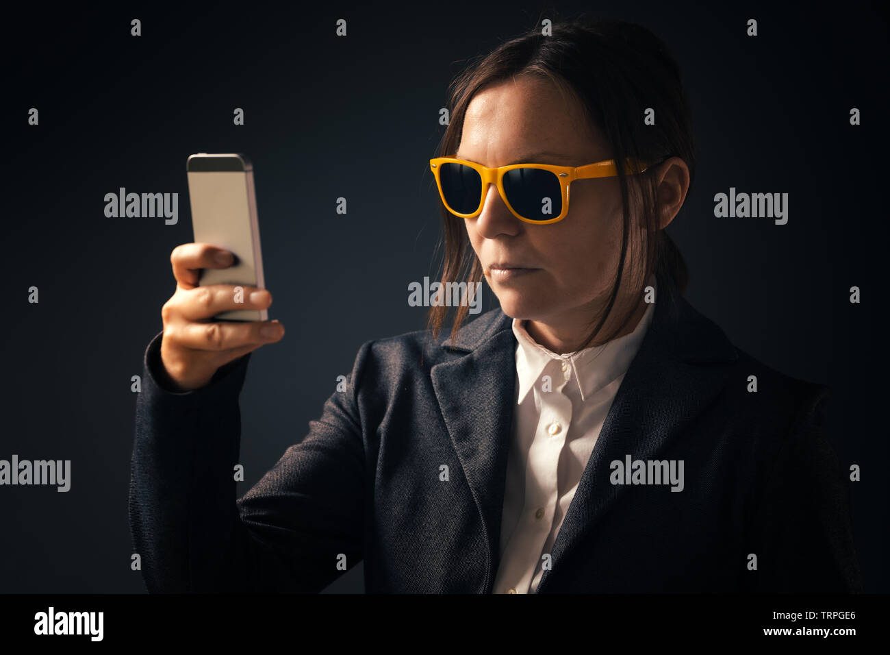 Kühle Geschäftsfrau, selfie Foto Portrait mit Smartphone. Nach kaukasische Frau im eleganten Anzug tragen gelbe Sonnenbrille posiert in Stockfoto