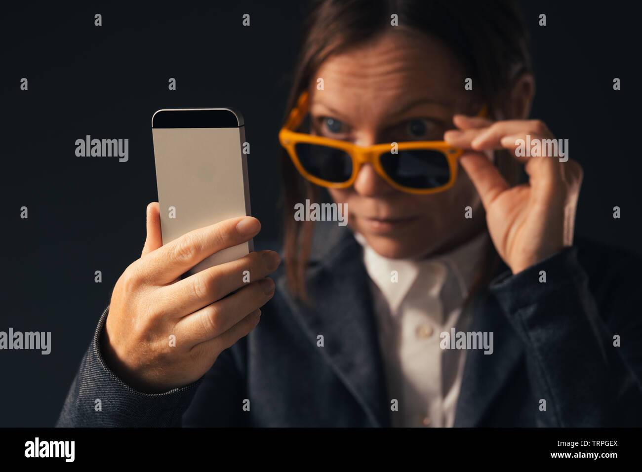 Kühle Geschäftsfrau, selfie Foto Portrait mit Smartphone. Nach kaukasische Frau im eleganten Anzug tragen gelbe Sonnenbrille posiert in Stockfoto