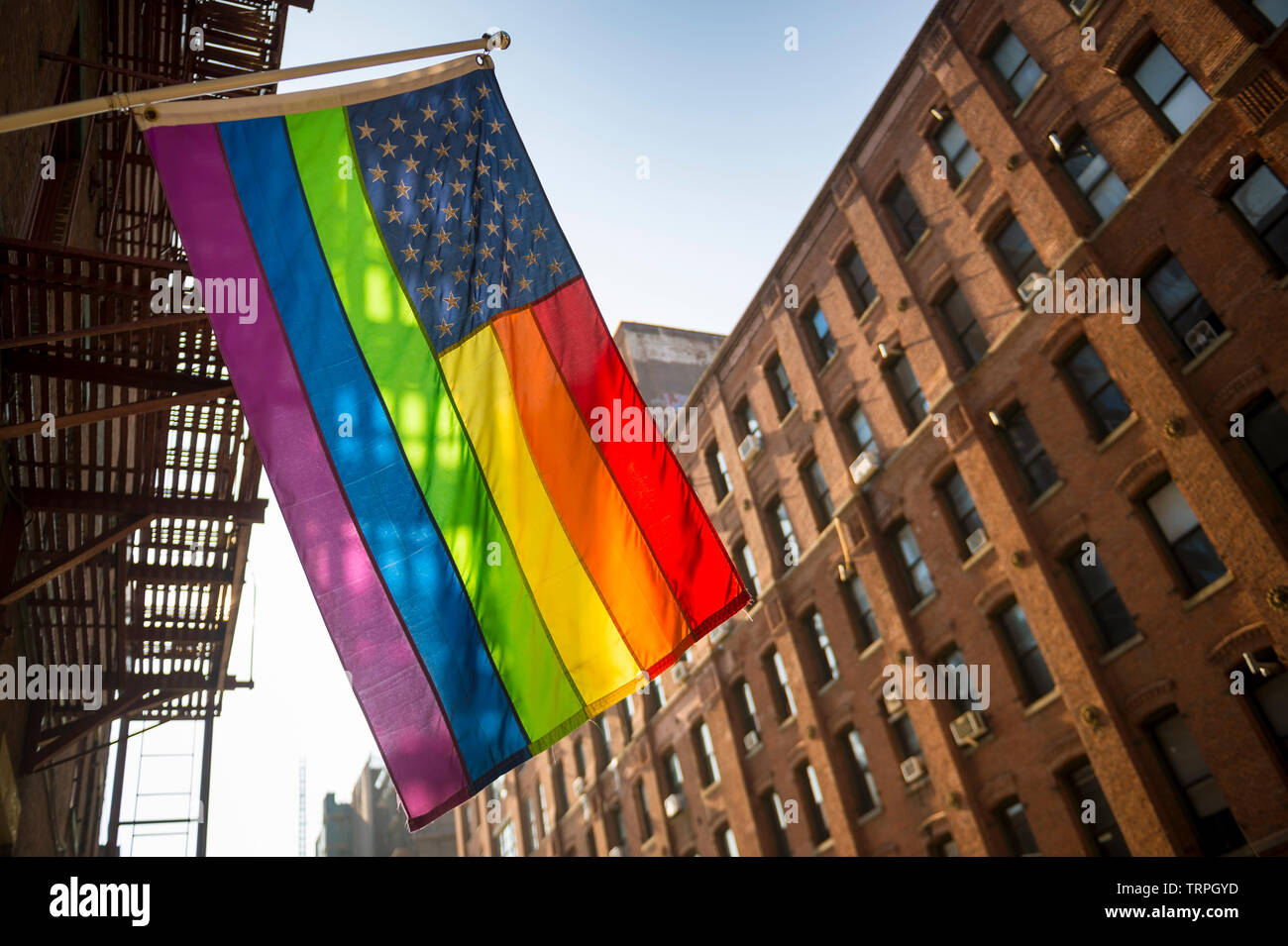 Amerikanische Flagge mit Stars und Gay Pride Regenbogen Streifen hängt von der traditionellen Gebäude in der liberalen Stadt New York, USA Stockfoto