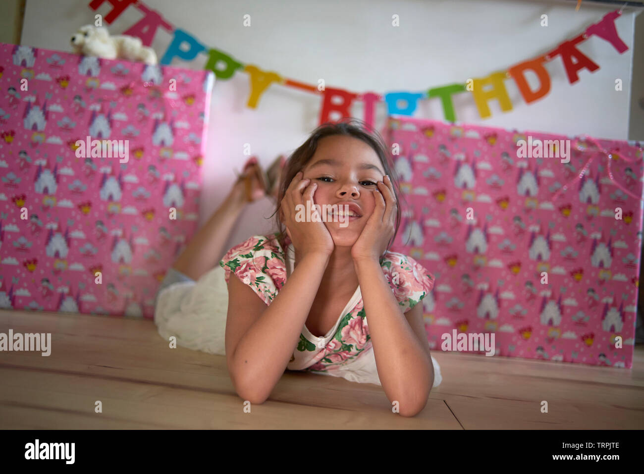 Süße Mischlinge asiatischen Mädchen vor einem Stapel Geburtstagsgeschenke zu Hause im Wohnzimmer von ihrer Familie umgeben Posing Stockfoto