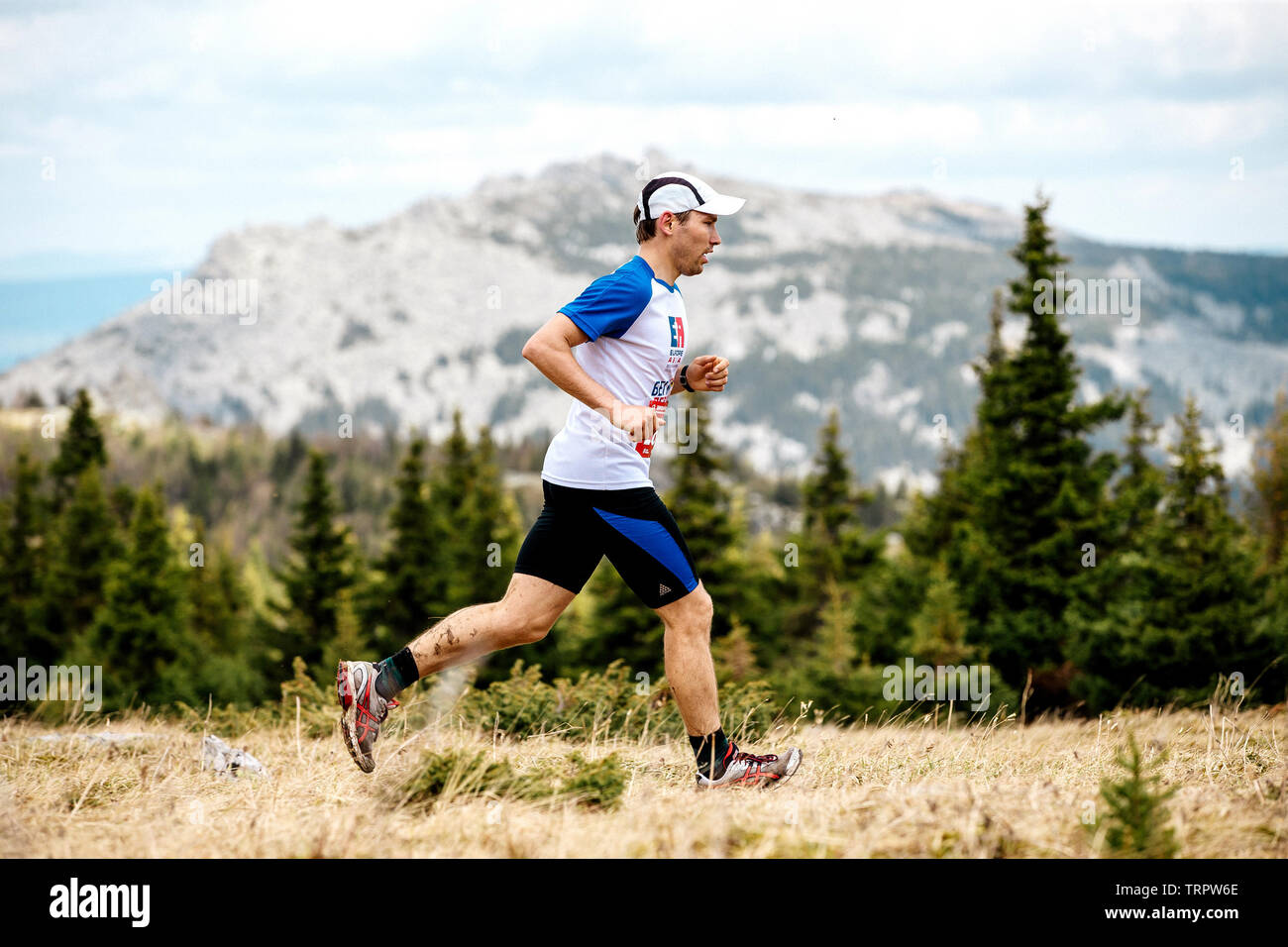 Eldan, Russland - Juni 1, 2019: männlich Runner running Trail auf Hintergrund Wald und Berg im Marathon Gesund wie Elche Stockfoto